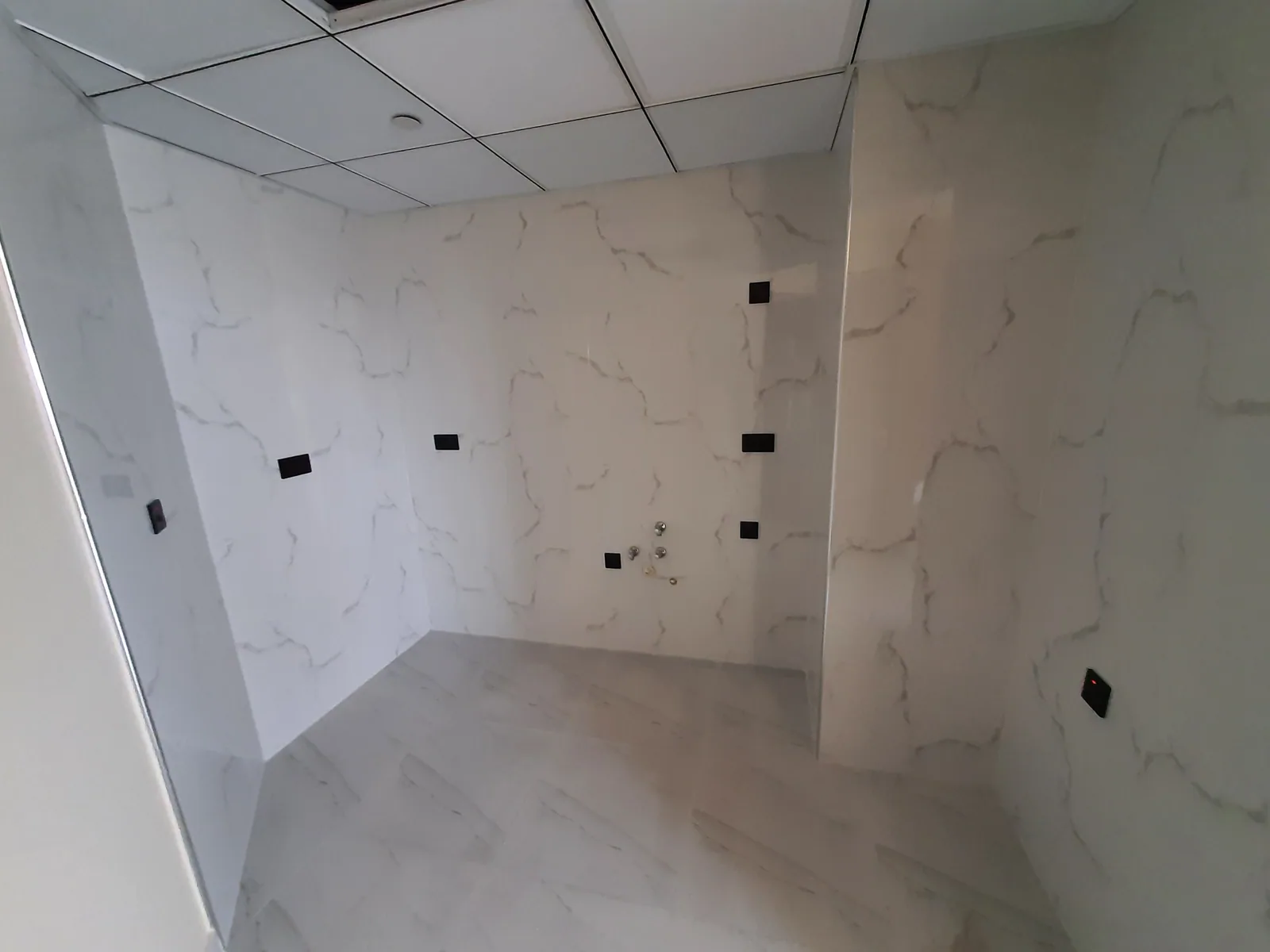 Marble-look kitchen walls prepared for custom cabinetry installation