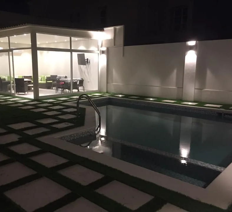 Completed poolside aluminum and glass room illuminated at night