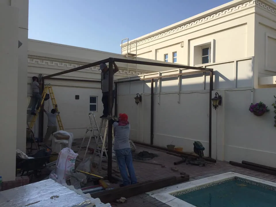 Aluminum and glass room framework being installed beside a villa pool