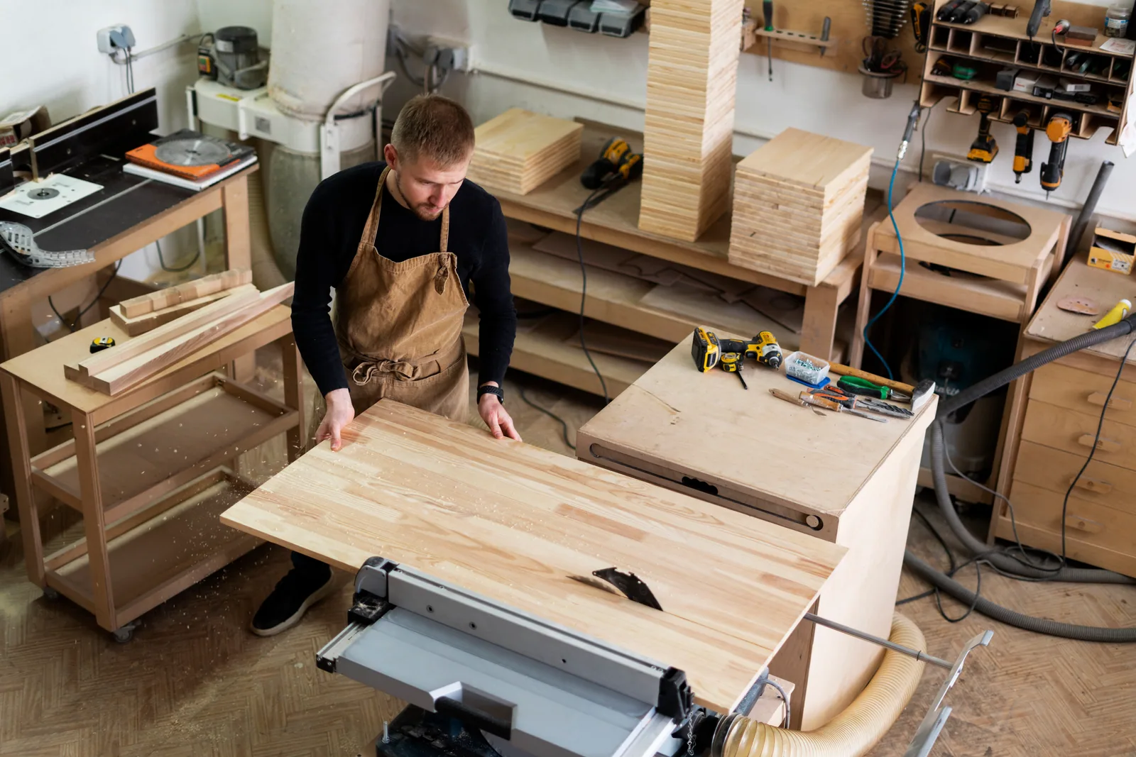 Carpenter cutting timber in a woodworking workshop